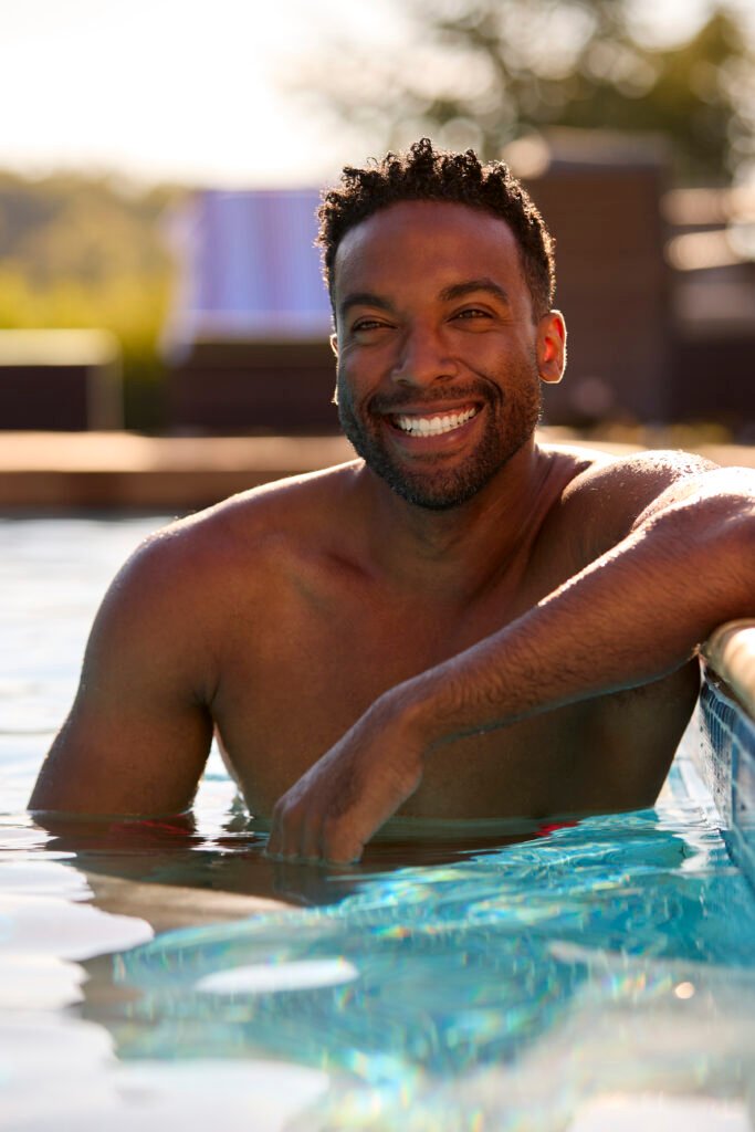 Portrait Of Smiling Man On Summer Holiday Relaxing In Swimming Pool